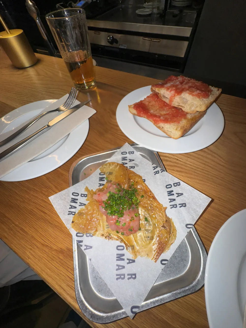 Desayuno de pan con tomate y jamón en la barra de un bar