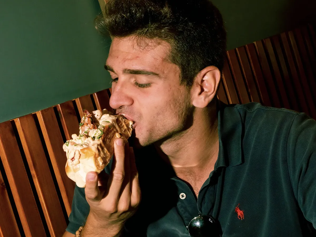 Un cliente dando un bocado a un sándwich de Porky’s