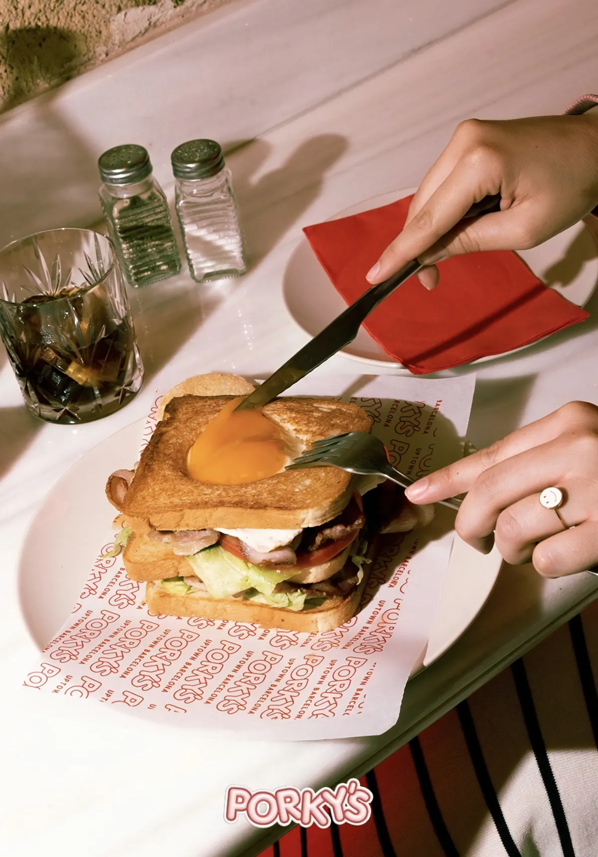Sándwich de Porky’s abierto con huevo, cortado sobre el papel