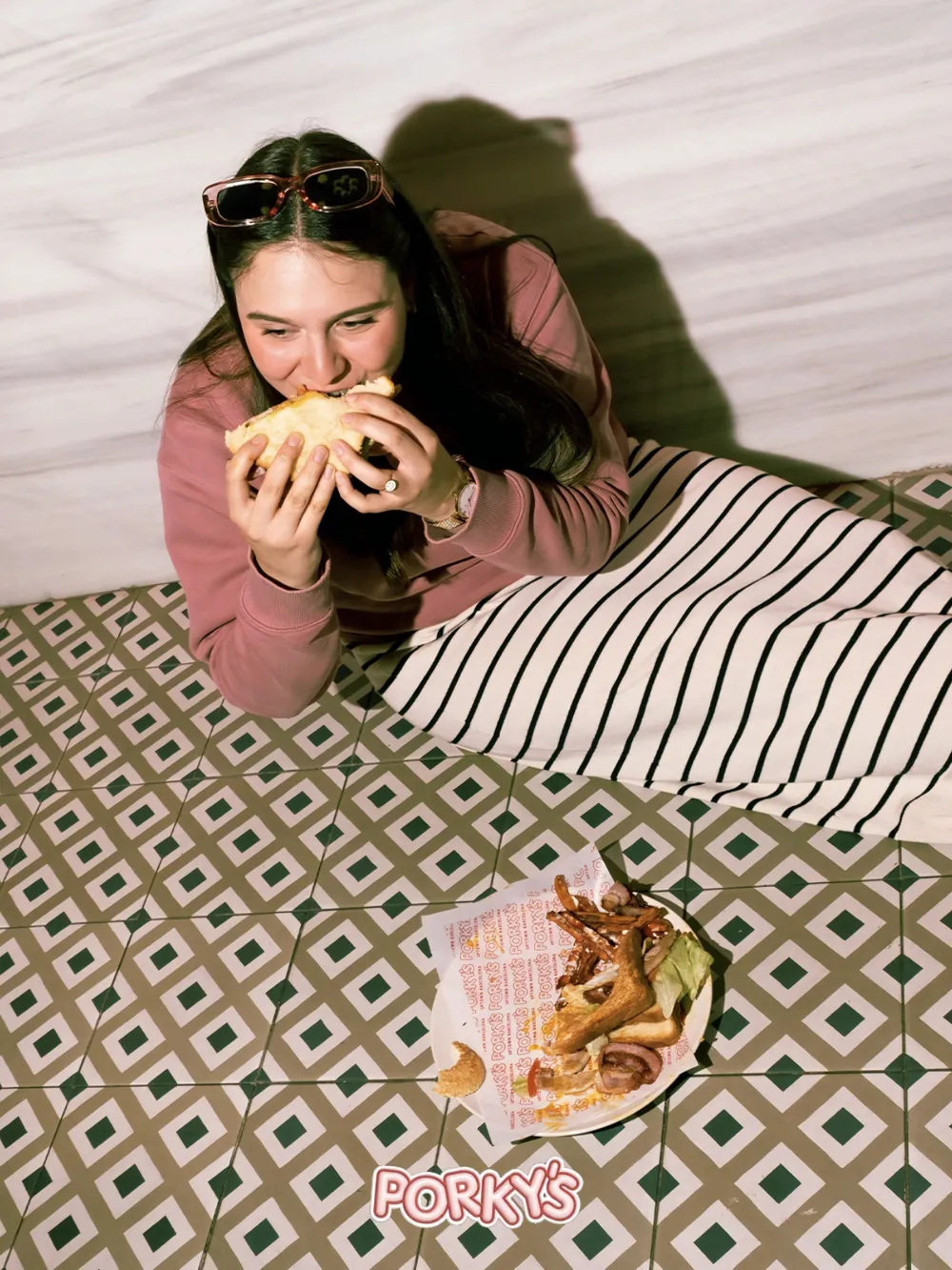 Una clienta comiendo un bocadillo en la terraza de Porky’s