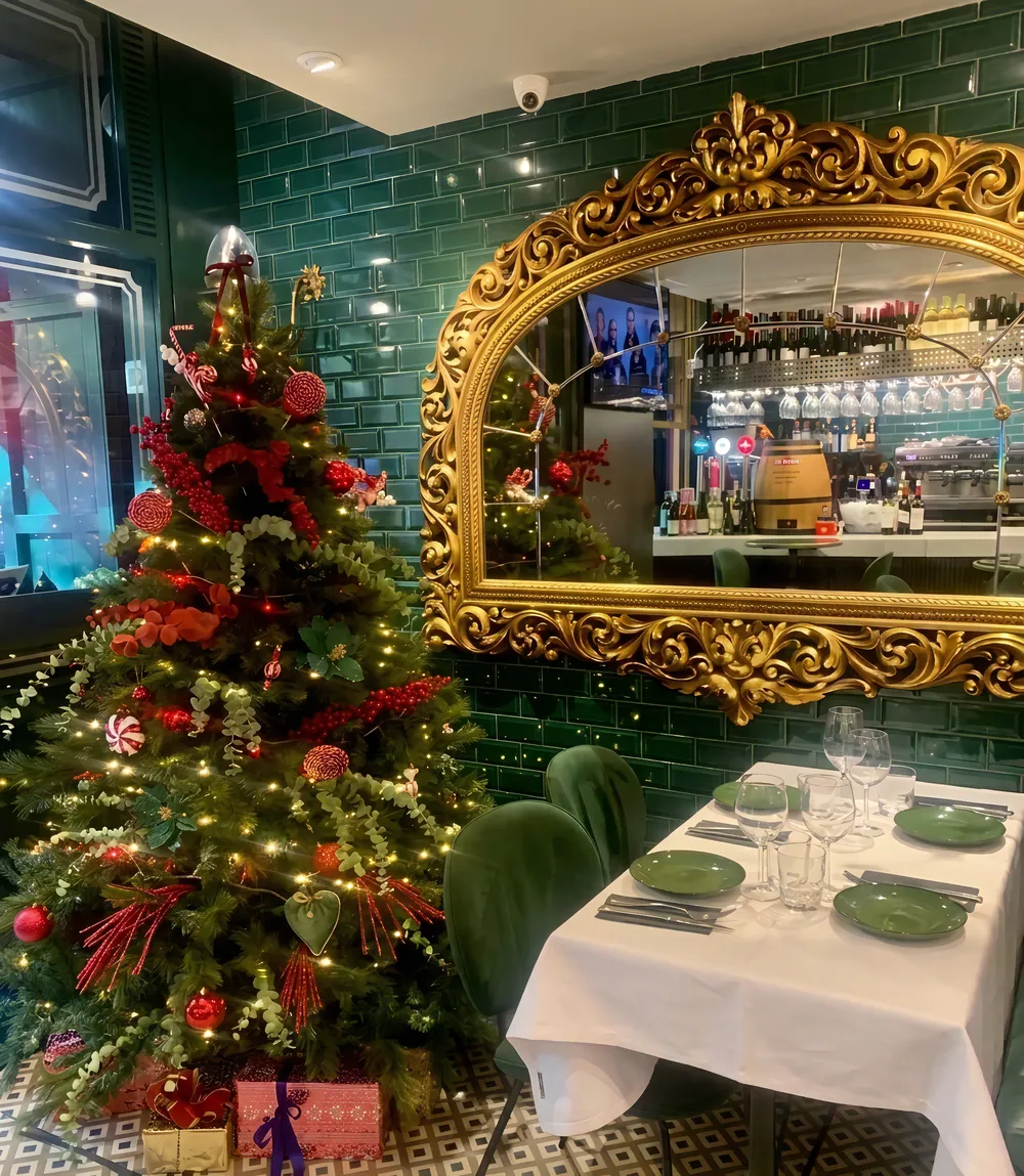 Comedor de La Raspa en Navidad, con el árbol decorado y un gran espejo dorado